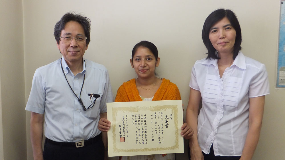 大島賞受賞を喜ぶザーマン・シンシアさん（中央）と神谷茂教授（左側）、大崎敬子講師（右側）